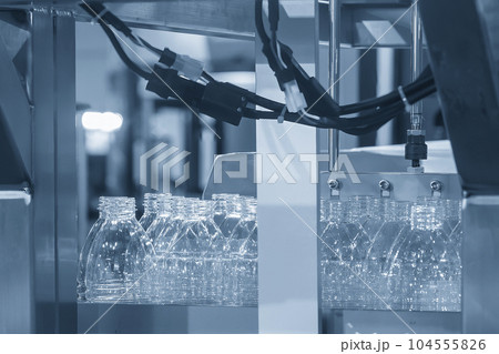 Close up scene of the empty drinking water bottles on the conveyor belt for filling process. Close up scene of the empty drinking water bottles on the conveyor belt for filling process. 104555826