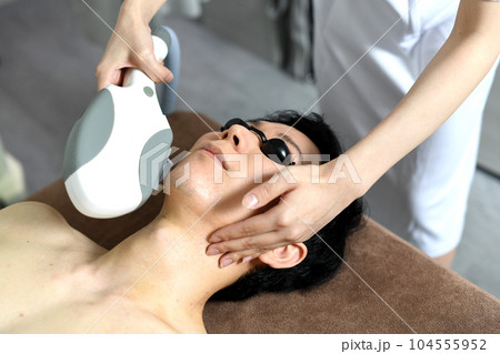 ヒゲの脱毛の施術を受ける若い男性 ヒゲの脱毛の施術を受ける若い男性 104555952