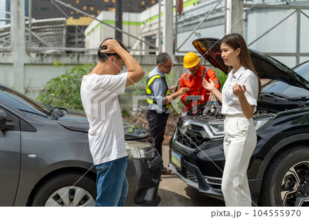 An unset young woman talking angryly to a man who accidentally drove his car and hit her car An unset young woman talking angryly to a man who accidentally drove his car and hit her car 104555970