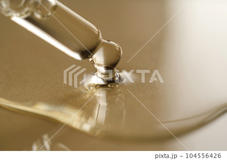Pipettes with oil or serum on a golden background. Pipettes with oil or serum on a golden background. 104556426