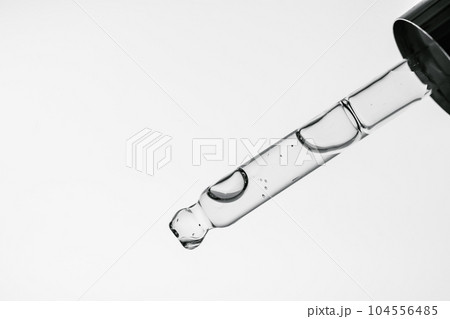 Transparent pipette with cosmetics on a white isolated background. Transparent pipette with cosmetics on a white isolated background. 104556485