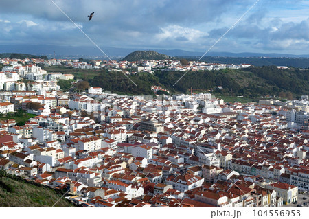 The city of Nazare in Portugal, the symbol of surfing. Coastline and view from above on the town. Tourist place with big waves. 104556953