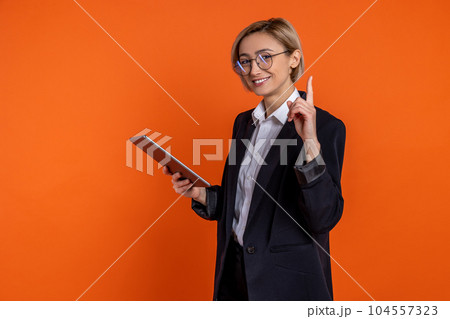 Intelligent woman in black official style suit using tablet raising finger having idea work project 104557323