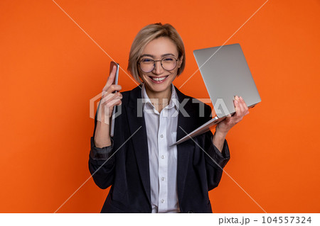 Satisfied woman wearing black official style suit working with laptop and tablet modern technology 104557324