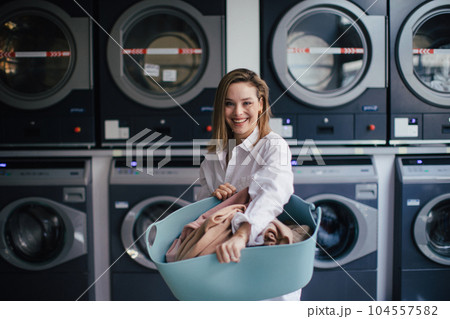 Young woman posing in a laundry room. Young woman posing in a laundry room. 104557582