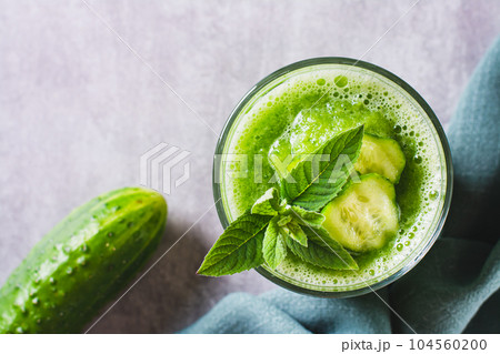 Close up of Refreshing cucumber and mint smoothie in a glass on the table top view 104560200