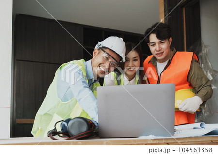 multi ethnic engineer brainstorming and measuring for cost estimating on blueprint and floor plan drawings about design architectural and engineering for houses and buildings. 104561358