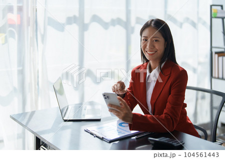 Portrait of beautiful young businesswoman standing smiling and using smartphone. Portrait of beautiful young businesswoman standing smiling and using smartphone. 104561443