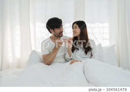 Asian Romantic couple in bed enjoying sensual foreplay Happy sensual young couple lying in bed together. Beautiful loving couple kissing in bed Asian Romantic couple in bed enjoying sensual foreplay Happy sensual young couple lying in bed together. Beautiful loving couple kissing in bed 104561479