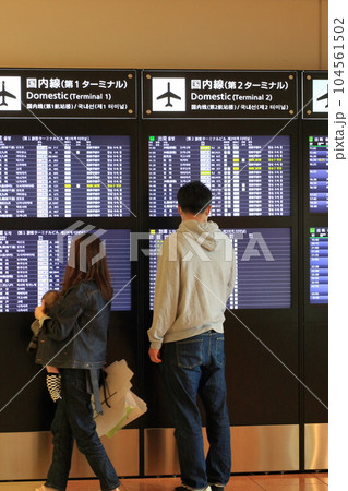 空港の時刻表を確認する旅行客 飛行機の時刻表 空港の時刻表を確認する旅行客 飛行機の時刻表 104561502
