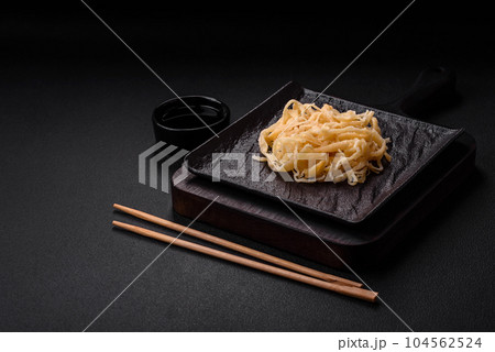 Delicious dried squid in the form of shavings with salt and spices Delicious dried squid in the form of shavings with salt and spices 104562524