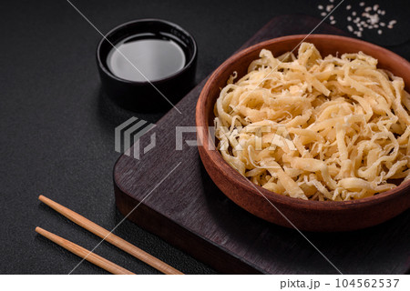 Delicious dried squid in the form of shavings with salt and spices Delicious dried squid in the form of shavings with salt and spices 104562537