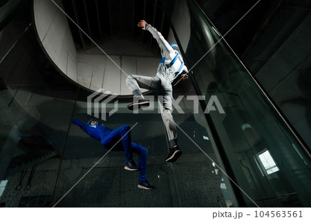 A man and a woman enjoy flying together in a wind tunnel. Free fall simulator 104563561