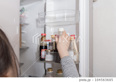 【冷蔵室からソースを出す主婦】 104563685