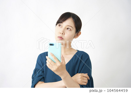 スマートフォンを持って考えるミドルエイジ女性　白背景 104564459