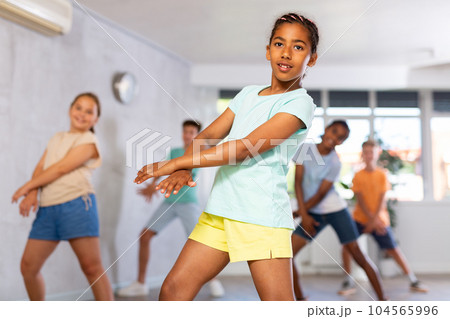 African girl perform choreographic exercises and teach energetic social dance waacking with friends 104565996