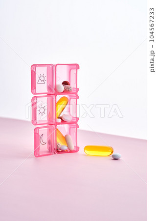 Bright pill box with different pills and vitamins. 104567233