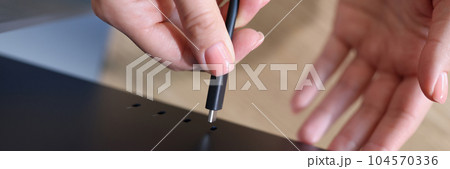 Woman hands connecting laptop screen using cable Woman hands connecting laptop screen using cable 104570336