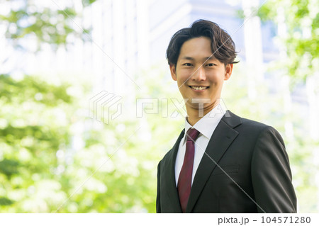 新緑の中外回りをする若いビジネスマン 新緑の中外回りをする若いビジネスマン 104571280