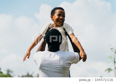 Father's Day Love: African American Dad Embracing Son in sunny day in the park 104572116