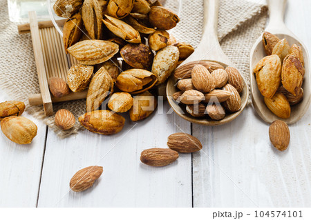 Almonds in a black bowl against dark rustic wooden background Almonds in a black bowl against dark rustic wooden background 104574101