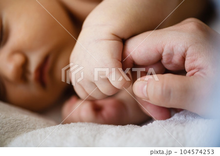 Close up baby hand catch mom finger 104574253