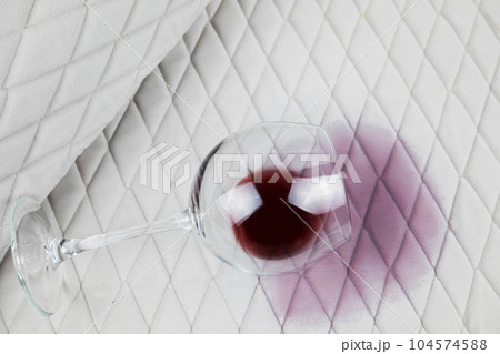 a spilled glass of wine on the tablecloth. Cleaning clothes and furniture from stains. 104574588