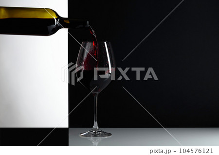 Red wine is poured into a glass. 104576121