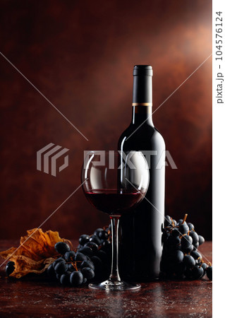 Red wine and grapes on a brown background. 104576124