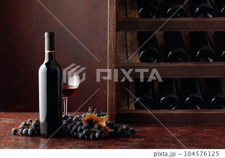 Red wine and grapes in wine cellar. 104576125