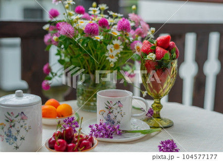 Morning tea with flowers and fruits on the terrace of a country house. 104577177