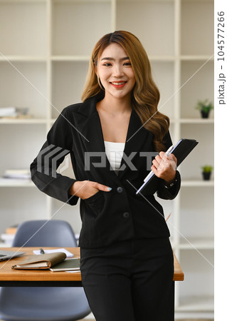 Portrait of female secretary, office manager or business assistant holding digital tablet standing in modern workplace Portrait of female secretary, office manager or business assistant holding digital tablet standing in modern workplace 104577266