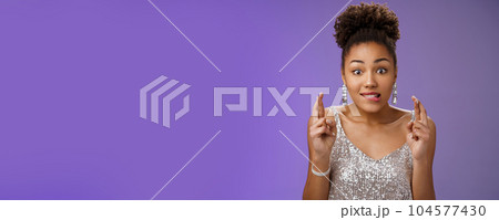 Excited african-american girl excited eager win cross fingers good luck biting lip desire anticipation making wish, eager receive gift, standing optimistic thrilled in silver dress blue background Excited african-american girl excited eager win cross fingers good luck biting lip desire anticipation making wish, eager receive gift, standing optimistic thrilled in silver dress blue background 104577430