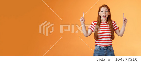 Surprised excited cheerful ginger girl see amazing opportunity, look pointing up amused, drop jaw gasping astonished, pleased awesome cool advertisement, reacting thrilled top copy space Surprised excited cheerful ginger girl see amazing opportunity, look pointing up amused, drop jaw gasping astonished, pleased awesome cool advertisement, reacting thrilled top copy space 104577510