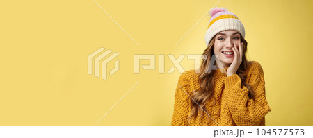Smiling attractive carefree young 20s woman having fun talking casually nice conversation girlfriend press palm cheek amused blushing receive flirty compliment, standing positive yellow background 104577573