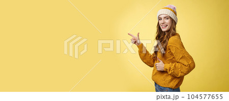 Profile shot charismatic flirty good-looking satisfied young girl turn camera pointing index finger left show thumbs-up like gesture approving recommending awesome place yellow background Profile shot charismatic flirty good-looking satisfied young girl turn camera pointing index finger left show thumbs-up like gesture approving recommending awesome place yellow background 104577655