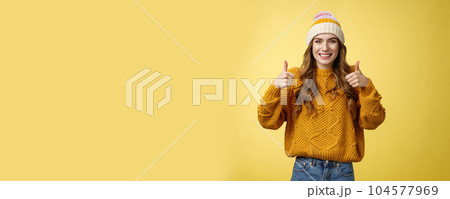 Supportive attractive 20s girl likes your idea show thumbs up positive reply affirmative answer standing pleased smiling recommending promotion satisfied give approval, agree yellow background Supportive attractive 20s girl likes your idea show thumbs up positive reply affirmative answer standing pleased smiling recommending promotion satisfied give approval, agree yellow background 104577969