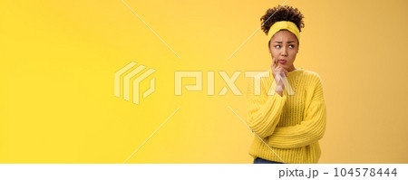 Perplexed unsure cute timid african-american female thinking how escape awkward situation smirking frowning concerned touch cheek thoughtful thinking nervously, worried yellow background Perplexed unsure cute timid african-american female thinking how escape awkward situation smirking frowning concerned touch cheek thoughtful thinking nervously, worried yellow background 104578444