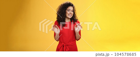 Girl hates washing dished grimacing from dislike and disgust wanting puke from aversion raising palms and stepping back frowning refusing displeasing offer over yellow background 104578685