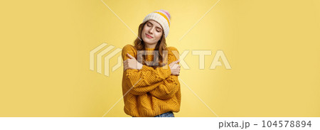 Tender sensual charming young girlfriend dreaming close eyes flirty smiling tilting head embracing herself recalling nice romantic memories wanna hold boyfriend tight, cuddling yellow background Tender sensual charming young girlfriend dreaming close eyes flirty smiling tilting head embracing herself recalling nice romantic memories wanna hold boyfriend tight, cuddling yellow background 104578894