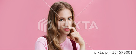 Cute feminine girl learning how make glances and seduce boyfriend with flirty gaze biting finger sensually posing against pink background, flirting making senducing look wearing make-up on date Cute feminine girl learning how make glances and seduce boyfriend with flirty gaze biting finger sensually posing against pink background, flirting making senducing look wearing make-up on date 104579001
