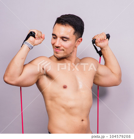 Fit young athlete preparing for bicep muscle arms exercise. Isolated over grey studio background. Fit young athlete preparing for bicep muscle arms exercise. Isolated over grey studio background. 104579208