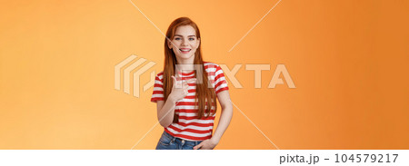 Carefree modern 20s female student chatting friends discuss left copy space, pointing left relaxed casual pose, smiling camera joyfully, introduce advertisement product, orange background Carefree modern 20s female student chatting friends discuss left copy space, pointing left relaxed casual pose, smiling camera joyfully, introduce advertisement product, orange background 104579217