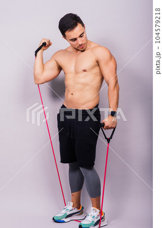 Fit young athlete preparing for bicep muscle arms exercise. Isolated over grey studio background. 104579218