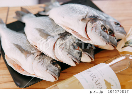 Raw Dorado fish on a black plate. Cooking Dorado in a cooking class. Raw fish, close-up. Homemade food, cooking at home. 104579817