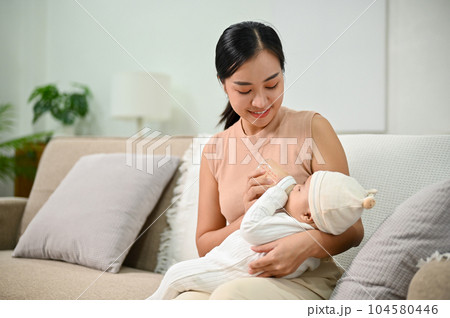 Portrait of cute newborn baby being fed by her mother using bottle. Portrait of cute newborn baby being fed by her mother using bottle. 104580446