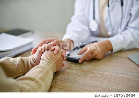 Close up view of doctor touching patient hand, showing empty and kindness. 104580484