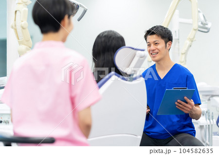 患者の治療をする歯科医師 104582635