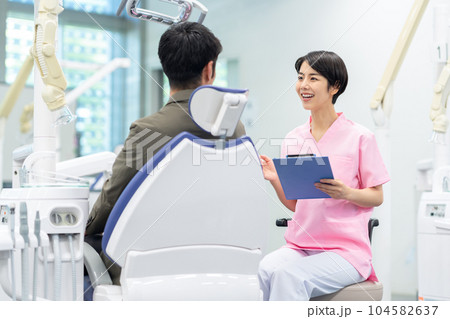 患者の治療をする歯科衛生士 患者の治療をする歯科衛生士 104582637