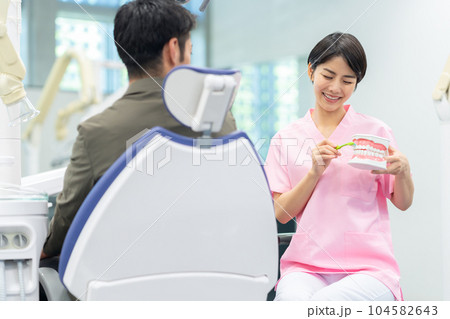患者の治療をする歯科衛生士 104582643